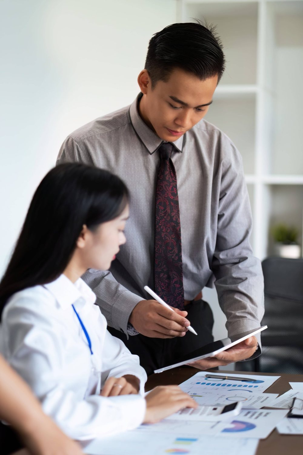 Financial consultant explaining grant application steps to small business owners in a meeting room.